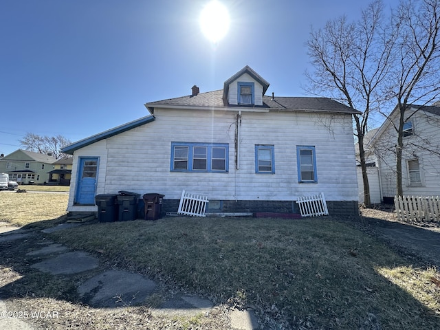 back of property featuring a lawn and a chimney