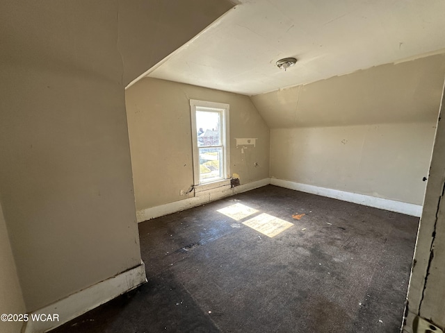 additional living space with baseboards and lofted ceiling