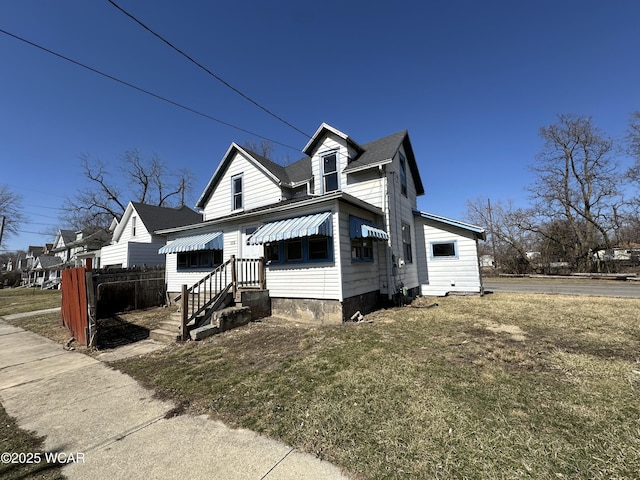 view of front of property with a front lawn and roof with shingles