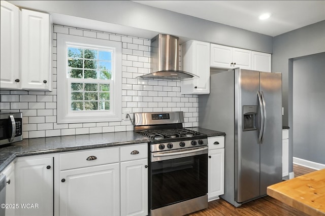 418 S Judkins Ave, Lima, OH 45805 - kitchen featuring stainless steel appliances, wall chimney exhaust hood, dark wood-style floors, white cabinetry, and tasteful backsplash