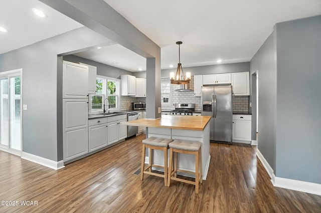 418 S Judkins Ave, Lima, OH 45805 - kitchen with stainless steel appliances, butcher block countertops, tasteful backsplash, a kitchen bar, and white cabinets