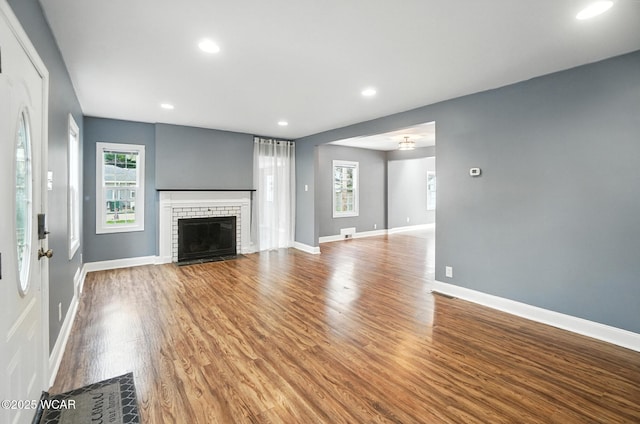 418 S Judkins Ave, Lima, OH 45805 - unfurnished living room with wood finished floors, a brick fireplace, and recessed lighting