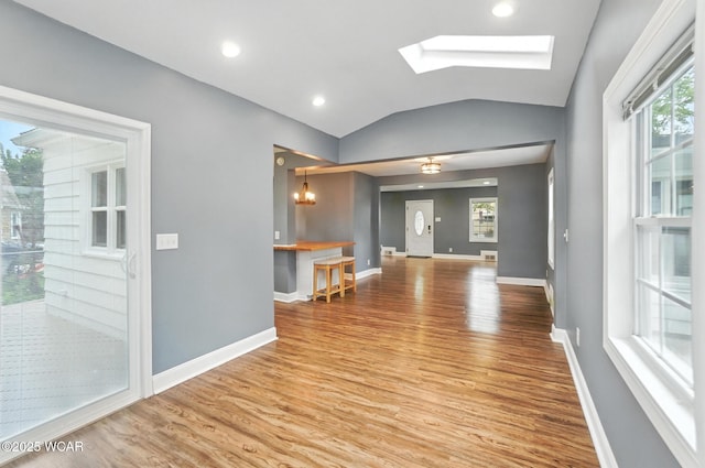 418 S Judkins Ave, Lima, OH 45805 - unfurnished living room featuring wood finished floors, vaulted ceiling, and a skylight