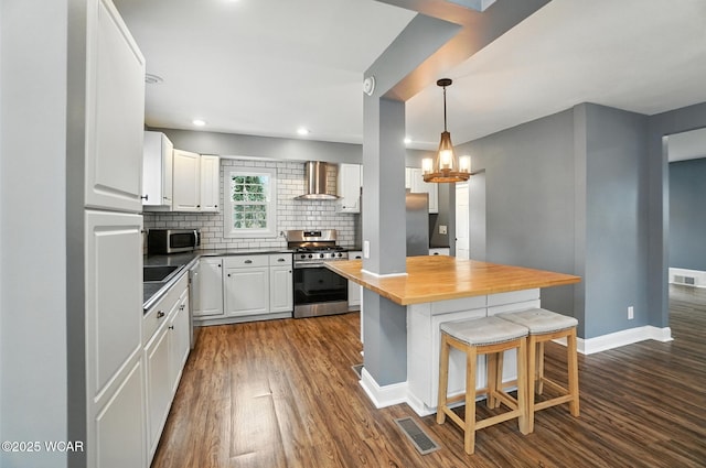 418 S Judkins Ave, Lima, OH 45805 - kitchen featuring stainless steel appliances, wall chimney range hood, wooden counters, dark wood-style flooring, and recessed lighting