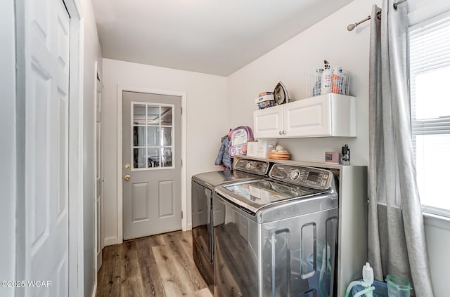 washroom with cabinets, washer and clothes dryer, and light hardwood / wood-style floors