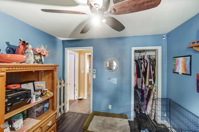 bedroom featuring ceiling fan, a closet, and dark hardwood / wood-style flooring