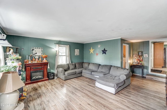 living room featuring light wood-type flooring and crown molding