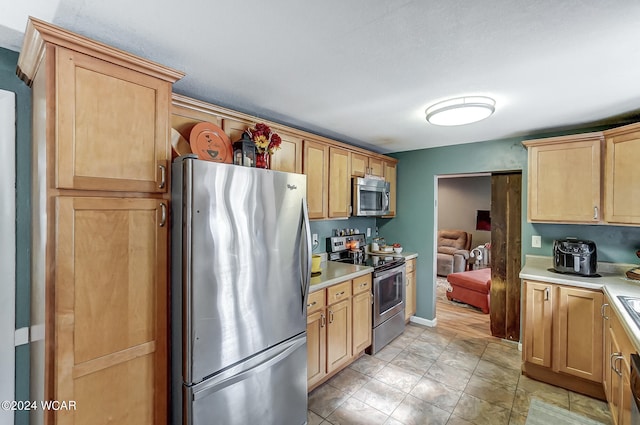 kitchen featuring stainless steel appliances and light brown cabinets