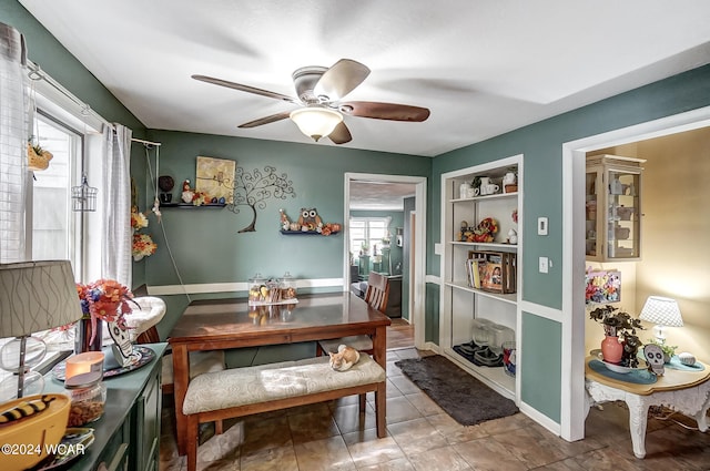 tiled dining room with ceiling fan and built in features