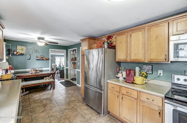 kitchen with ceiling fan, light tile patterned floors, stainless steel appliances, and light brown cabinets