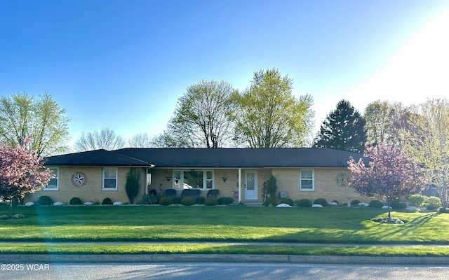 ranch-style home with a front yard and brick siding