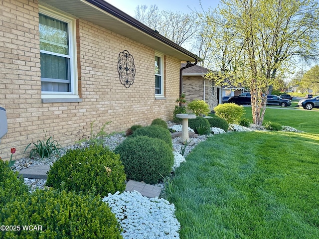 view of home's exterior with a lawn and brick siding