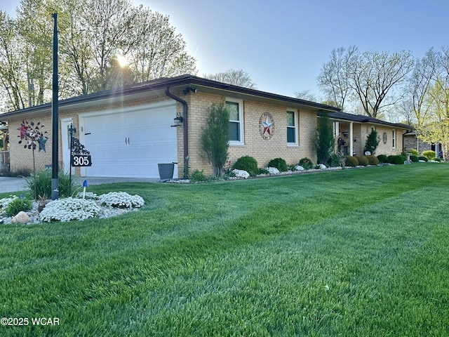ranch-style house featuring a front yard, brick siding, and a garage