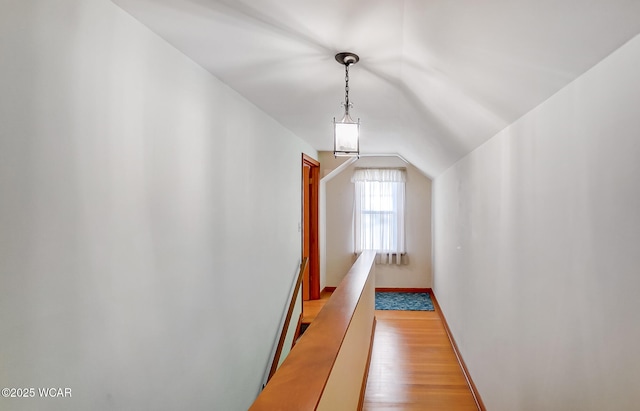 hallway featuring lofted ceiling and light hardwood / wood-style flooring