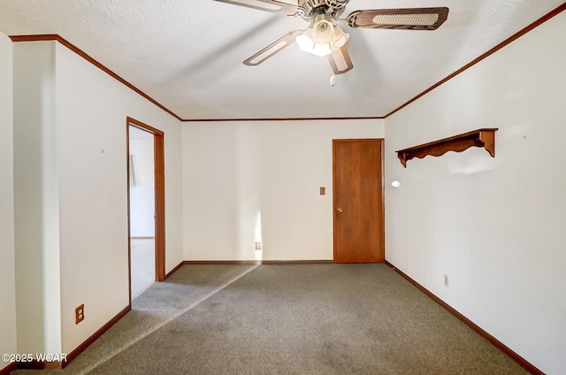 carpeted empty room featuring ceiling fan, ornamental molding, and a textured ceiling