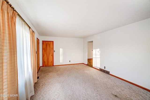 empty room featuring a healthy amount of sunlight and light carpet