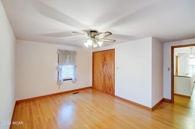 unfurnished bedroom featuring multiple windows, a closet, and light hardwood / wood-style flooring