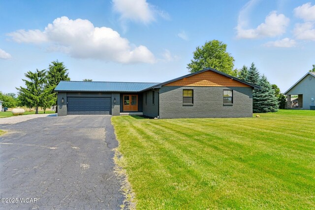 3485 Sugar Creek Rd, Lima, OH 45807 - view of front of home featuring a garage, driveway, brick siding, a front lawn, and a metal roof