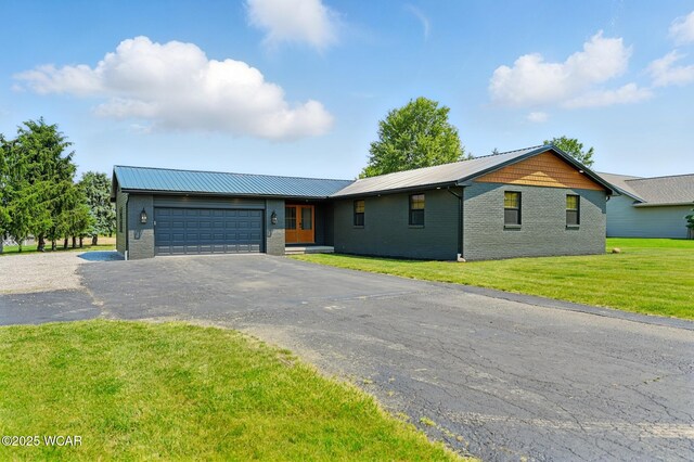 3485 Sugar Creek Rd, Lima, OH 45807 - view of front of home featuring brick siding, a garage, asphalt driveway, a metal roof, and a front lawn
