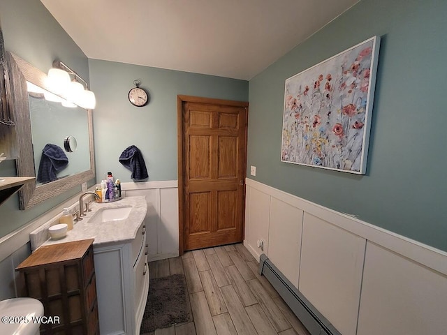 bathroom featuring wood tiled floor, a wainscoted wall, and vanity