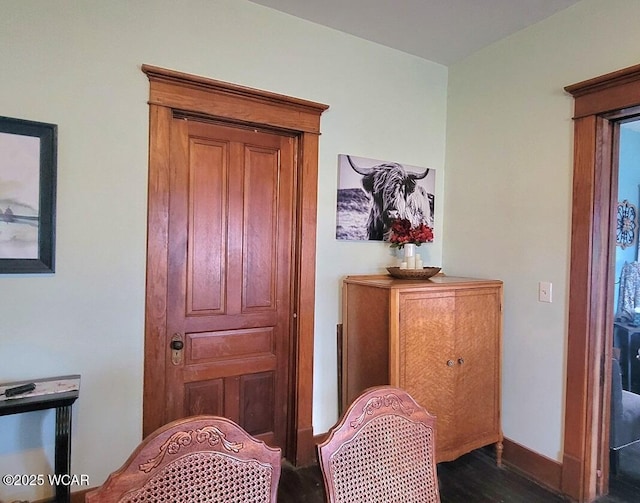 sitting room with dark wood finished floors and baseboards