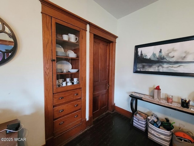 interior space featuring baseboards and wood finished floors