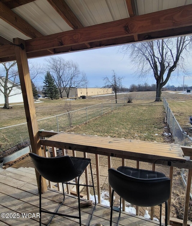 wooden deck with a rural view and fence