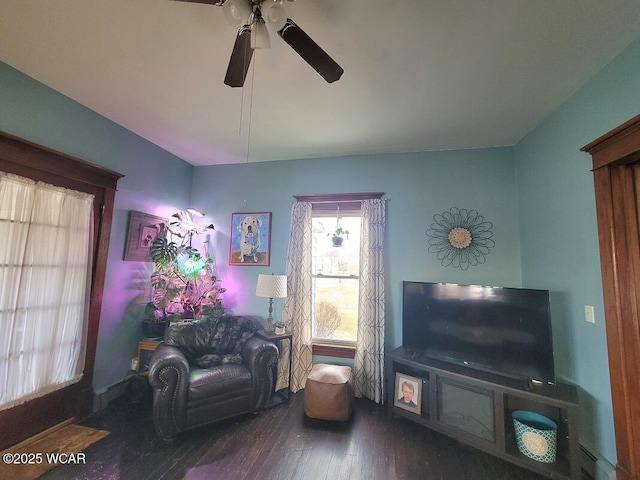 living area with dark wood-type flooring and a ceiling fan