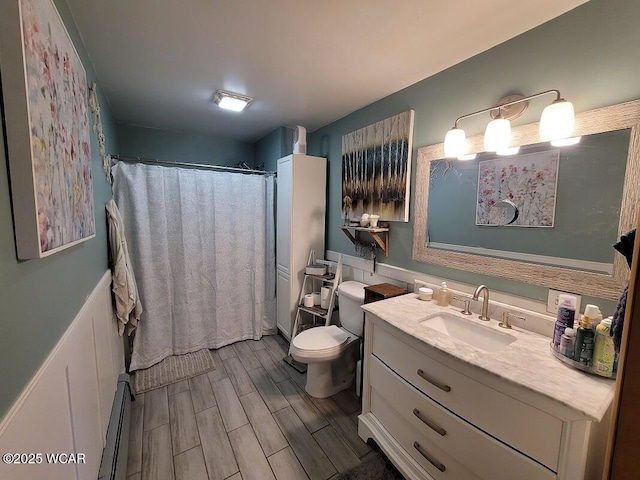 bathroom with toilet, baseboard heating, vanity, and wood tiled floor