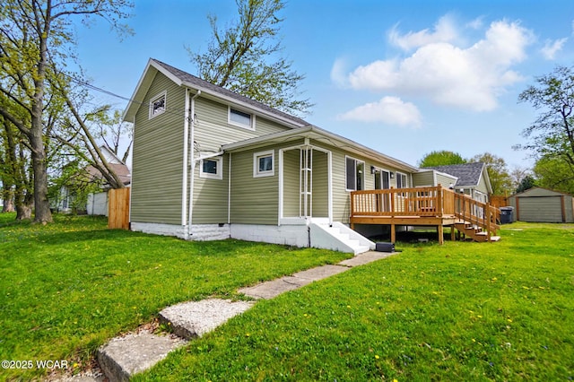 rear view of house featuring a storage shed, an outbuilding, a yard, and a deck
