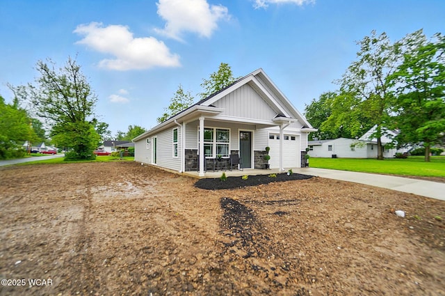 1501 W Spring St, Lima, OH 45805 - craftsman-style house with covered porch, concrete driveway, an attached garage, board and batten siding, and stone siding