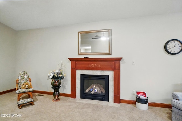 living room featuring baseboards, a tile fireplace, and carpet floors