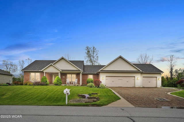 single story home featuring driveway, brick siding, covered porch, a garage, and a front lawn