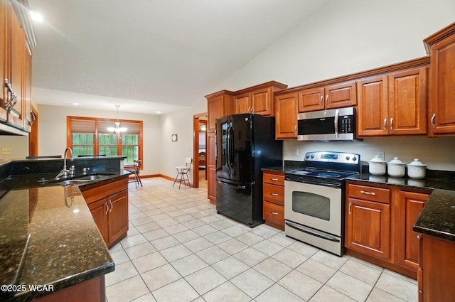 kitchen featuring light tile patterned flooring, a sink, vaulted ceiling, brown cabinets, and appliances with stainless steel finishes