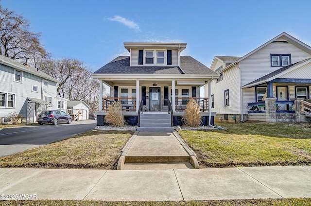 view of front of home featuring a porch, a front lawn, and roof with shingles