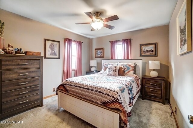 bedroom featuring a ceiling fan, light colored carpet, and baseboards