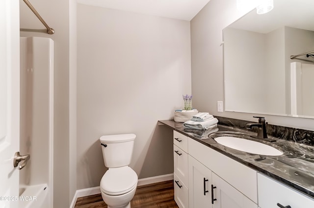 full bathroom featuring shower / bathing tub combination, toilet, vanity, wood finished floors, and baseboards