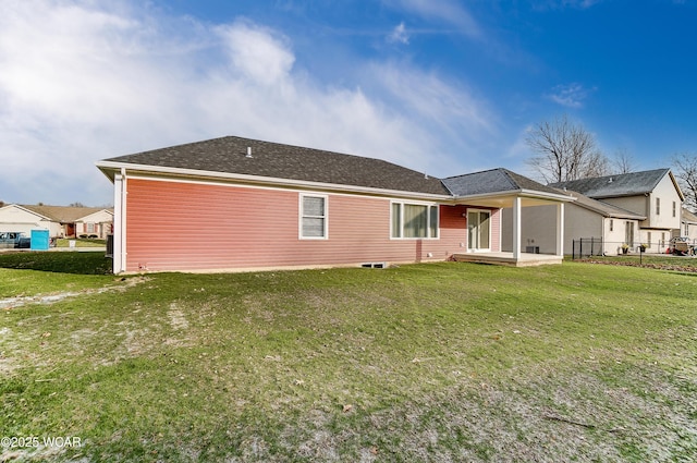 back of property with roof with shingles, a patio area, a lawn, and fence