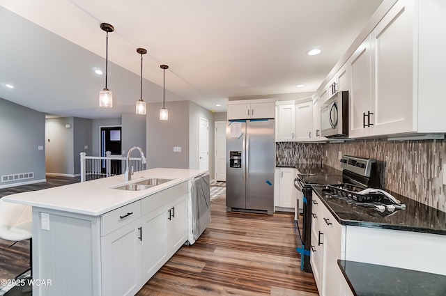 kitchen featuring visible vents, appliances with stainless steel finishes, a sink, and white cabinetry