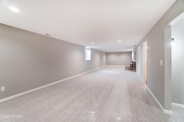 basement featuring baseboards, light colored carpet, and recessed lighting