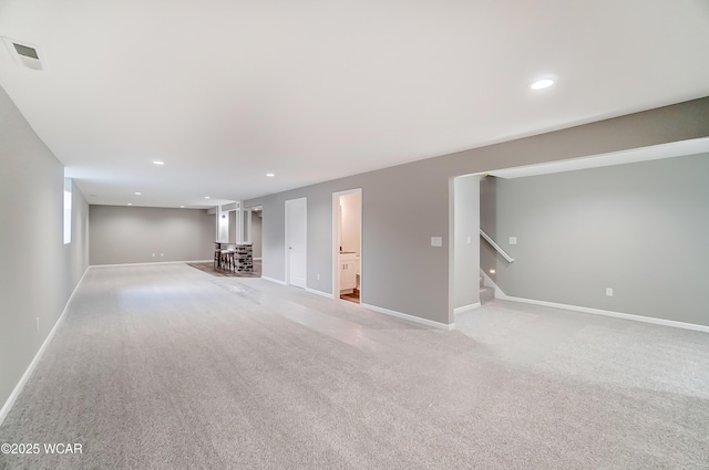 finished basement with light carpet, stairs, baseboards, and recessed lighting