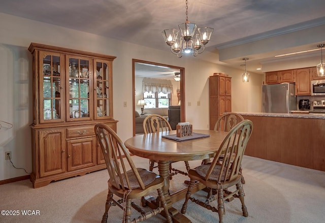 dining area featuring light carpet, baseboards, and ceiling fan with notable chandelier