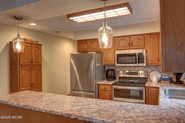 kitchen with decorative backsplash, pendant lighting, appliances with stainless steel finishes, and a sink