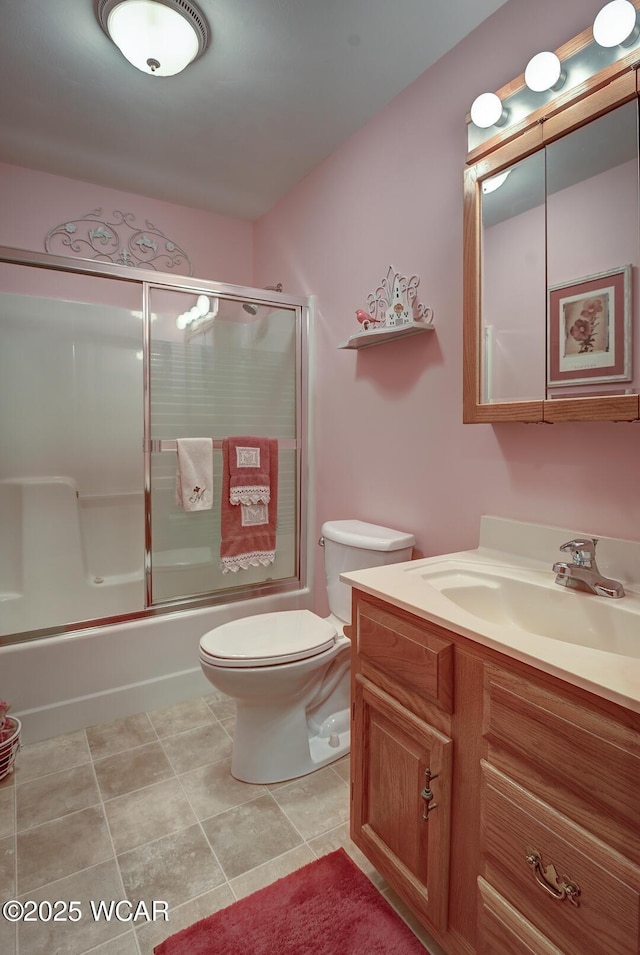 bathroom featuring vanity, toilet, shower / bath combination with glass door, and tile patterned flooring