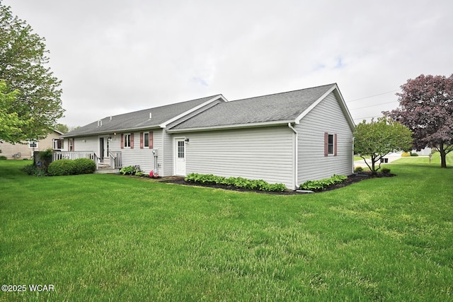 exterior space featuring roof with shingles and a lawn