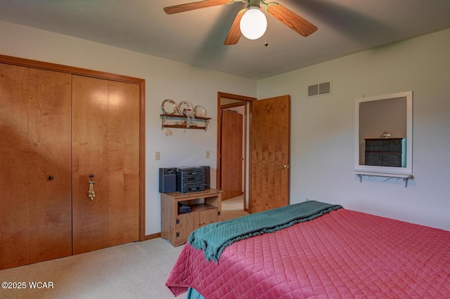 carpeted bedroom with ceiling fan, a closet, and visible vents