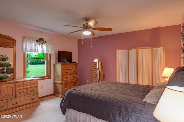 bedroom featuring light carpet, baseboards, and a ceiling fan