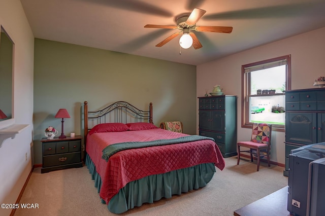bedroom with light carpet, baseboards, and a ceiling fan