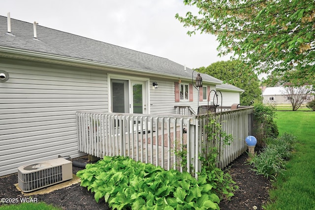 exterior space featuring central AC unit, a wooden deck, and a shingled roof