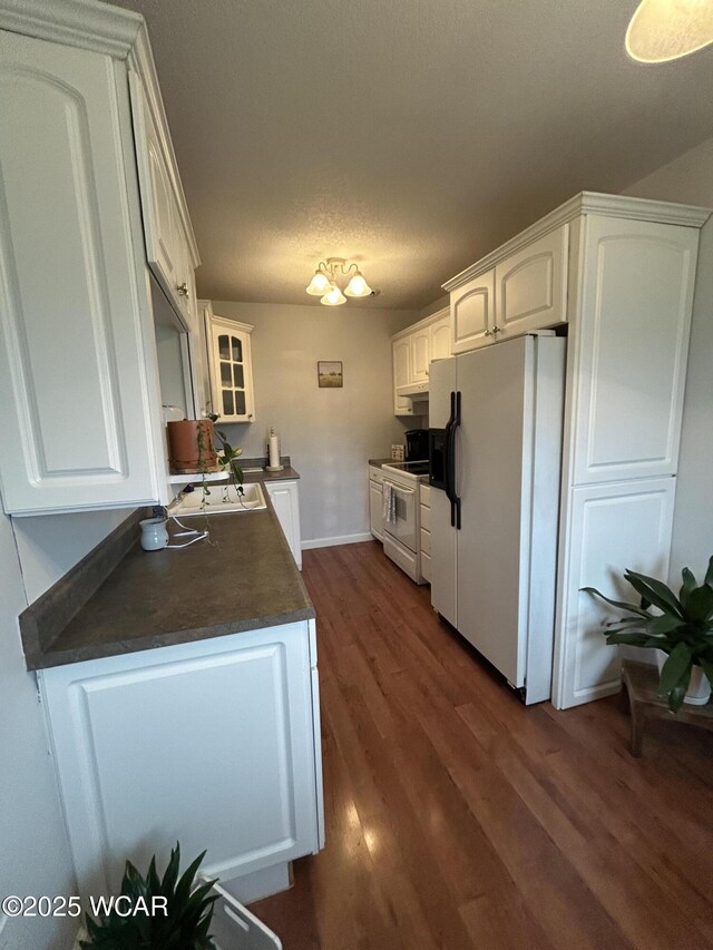 2275 N Cable Rd Unit 60, Lima, OH 45807 - kitchen featuring a sink, white appliances, dark countertops, white cabinets, and dark wood-style flooring